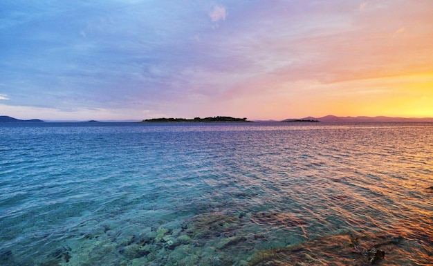 Foto aguas azules claras al atardecer cerca de drage, croacia