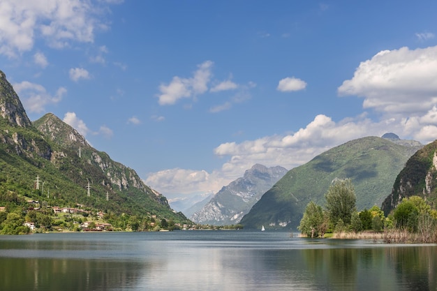 águas calmas do lago alpino Idro Lago d'Idro cercado por rochas e montanhas arborizadas Lombardia Itália