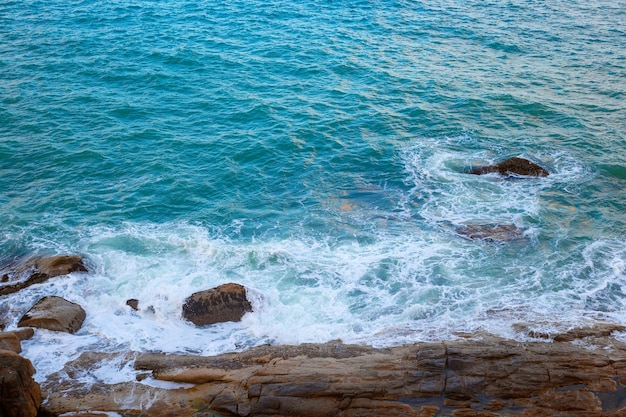 Aguas de mar tormentosas golpeando las rocas en la orilla vista desde arriba Seascape