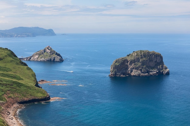 Águas rasas turquesas da costa rochosa do golfo da biscaia e eremitério dedicado a joão batista