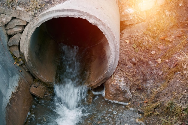 Las aguas residuales fluyen desde una tubería hacia el río Abordar la contaminación Gestionar las aguas residuales y la ecología de los ríos Aguas tóxicas de mal olor