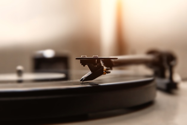 Una aguja tocando un vinilo viejo. Vista de cerca.