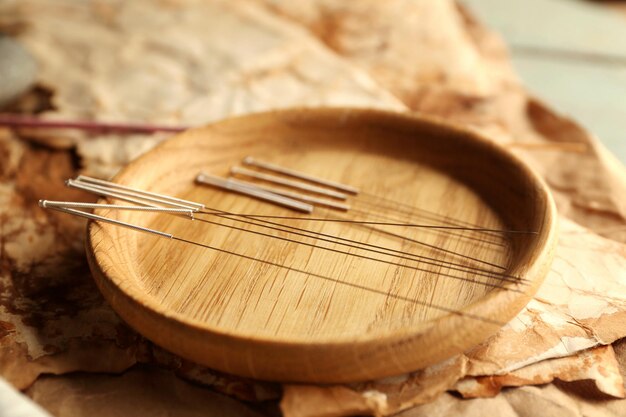 Agujas de acupuntura en mesa de madera