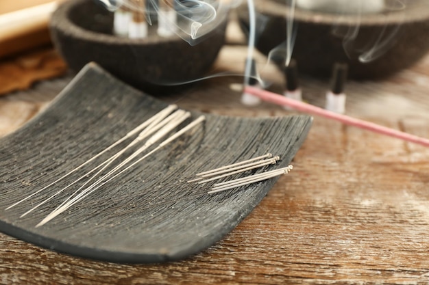 Agujas de acupuntura en mesa de madera