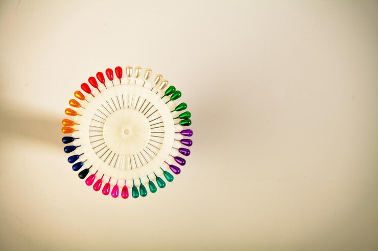 Foto agujas de coser un carrete de hilos de coser de colores para sastres sobre un fondo blanco aislado