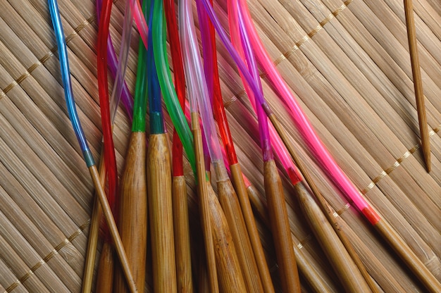 Agujas de tejer de bambú circular sobre una superficie de madera.