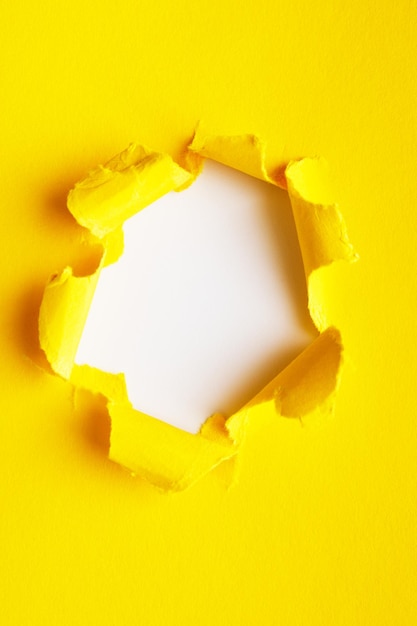 Foto agujero amarillo en el papel con lados rasgados