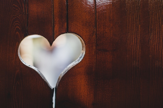 Agujero en forma de corazón en el panel de madera