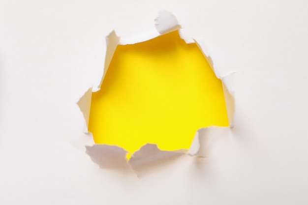 Agujero en papel sobre fondo amarillo, espacio para texto