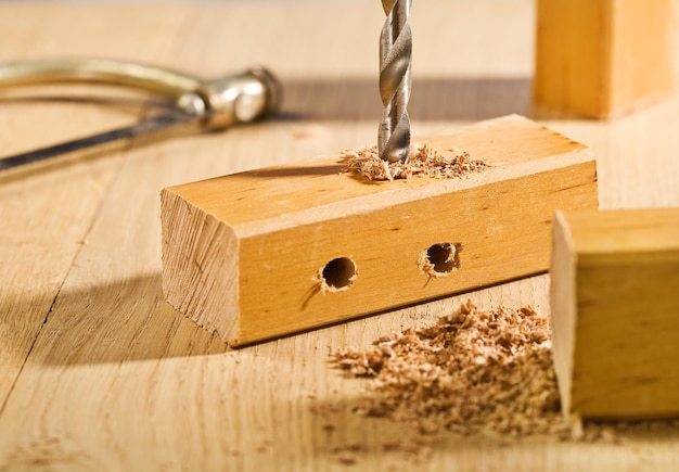 Agujero de perforación en un tablón de madera sobre la mesa