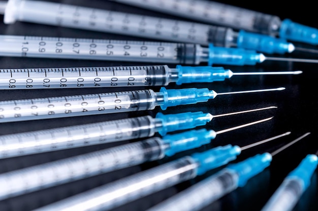 Agulha de seringas médicas em fundo preto Feche o conceito de cuidados de saúde da seringa