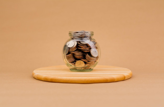 Ahorrar dinero en una botella de vidrio Monedas de finanzas e inversión que generan ingresos flujo de efectivo ingresos salarios fondos mutuos dividendos