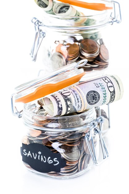 Ahorrar dinero en un frasco de vidrio para futuras inversiones.