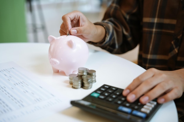 Ahorrar dinero mano poner dinero en la alcancía rosa hacer inversiones o estrategia