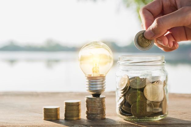 Ahorrar dinero y poner dinero a mano en el frasco de vidrio para fines financieros y contables.