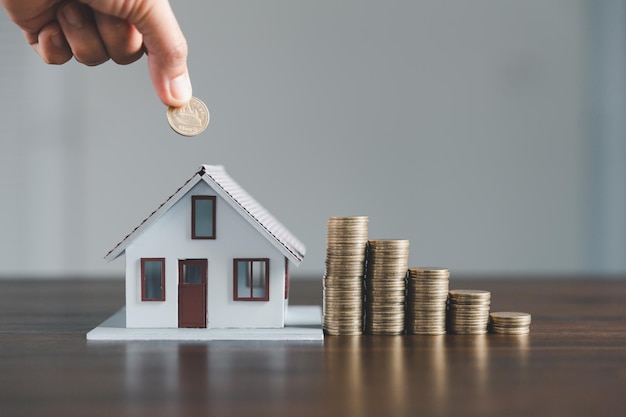 Ahorro de casa de inversión con concepto de negocio de dinero de financiación de préstamos Financiamiento de banca de inversión para negocios de bienes raíces residenciales Pila de monedas con casa modelo para préstamos de inversión Dinero en efectivo para impuestos
