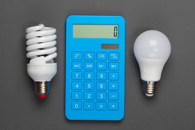 Foto el ahorro de energía. calculadora con bombillas en gris