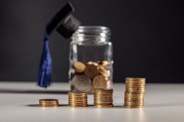 Ahorro para el tema de la educación. Monedas en tarro con sombrero de graduación.