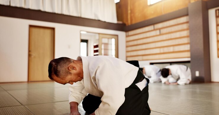 Foto aikido classe sensei e alunos com arco artes marciais ou respeito para a calma no treinamento de ginásio ou dojo pessoas japonesas chão e clube para exercício treino e aptidão física com luta pronto e batalha