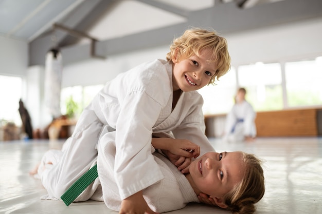 Aikido juntos. Hermano y hermana de pelo rubio se sienten felices haciendo aikido juntos