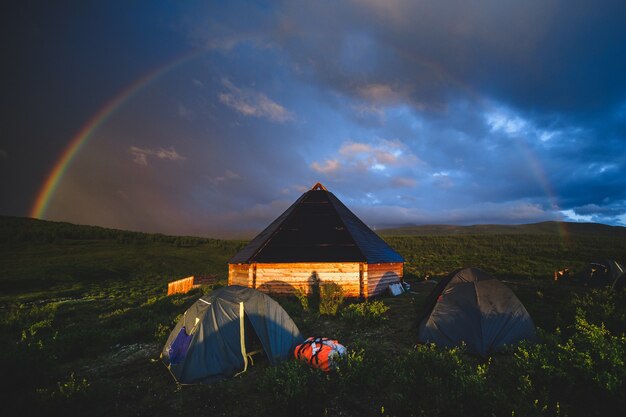 Ail das traditionelle Altai-Haus und Touristenzelte unter der Regenbogenkuppel im Ongudaysky-Bezirk der Altai-Republik, Russland