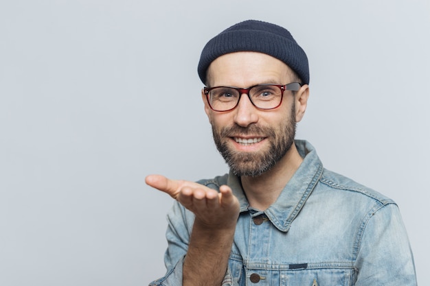 Ainda bem que homem barbudo de óculos da moda expressa seu amor, mostra beijo no ar, tem expressão alegre