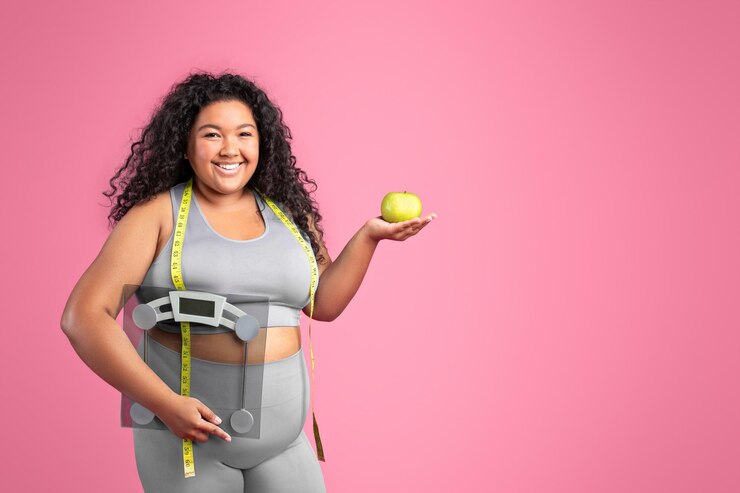 Foto ainda bem que uma mulher negra positiva em roupas esportivas segurando maçã e balança aproveitando o resultado da dieta rosa