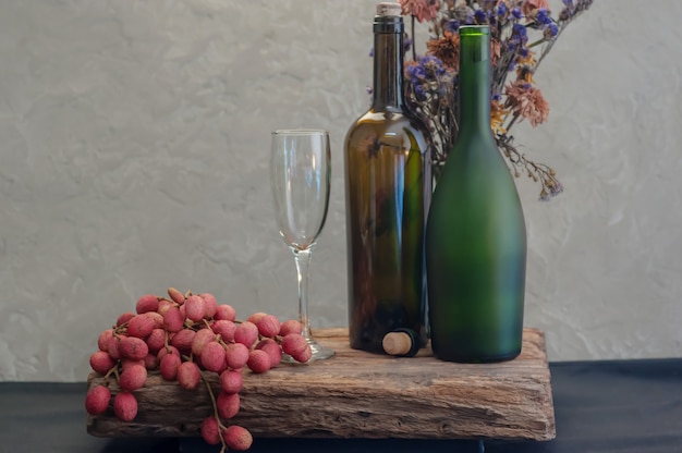 Ainda vida com vinho e lichia, garrafa no vaso de flor