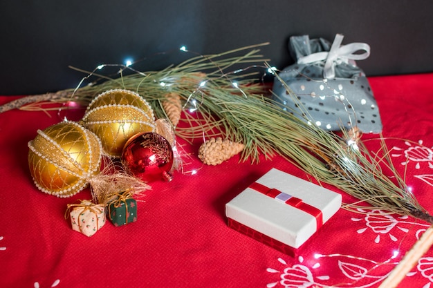 Ainda vida de acessórios de Natal em fundo preto e toalha de mesa vermelha