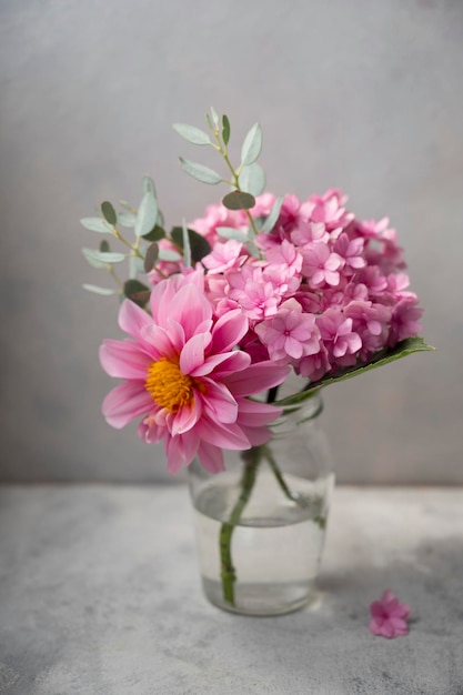 Ainda vida flor rosa bouwuet rosa hortênsia e dálias em vaso de vidro em fundo neutro foco seletivo suave