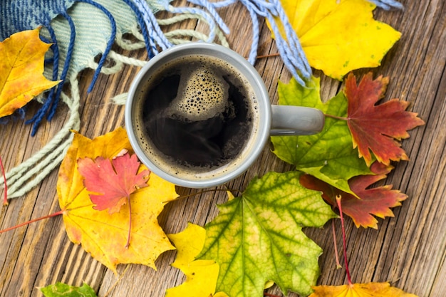 Ainda vida uma xícara de café e folhas de outono com manta