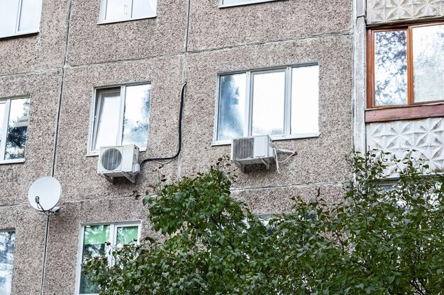 Aire acondicionado y antena en ventanas de casa alta