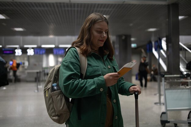 Airport terminal caucasian beautiful woman with luggage and walking in the airport using a mobile