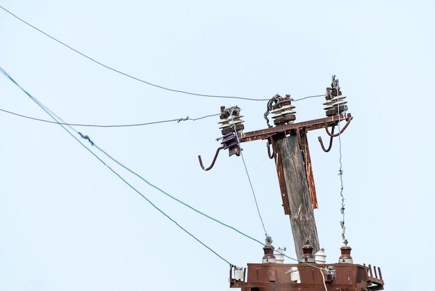 Aisladores eléctricos y cables en un poste antiguo