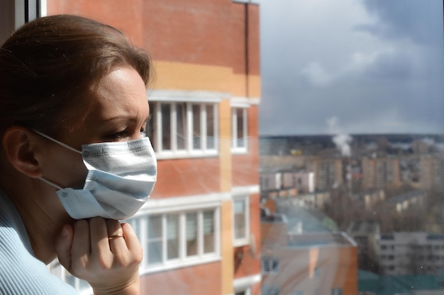 Aislamiento forzado La mujer de la máscara se ve triste mujer en máscara médica