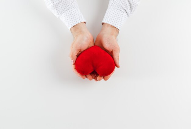 Aislante rojo de la mano del corazón en muchacha en blanco