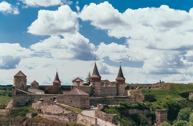 Ajardine a vista ensolarada do verão e o céu azul com nuvens na fortaleza e na cidade velha em Kamenetz Podolsky Ucrânia