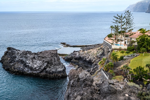 Ajardine con una villa en la costa de la costa volcánica, el océano Atlántico.