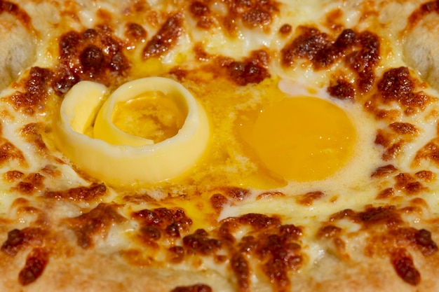 Ajarian Khachapuri, gefüllt mit Käse und garniert mit rohem Ei und Butter, traditionelles georgisches Khachapuri mit mit Käse gefülltem Brot