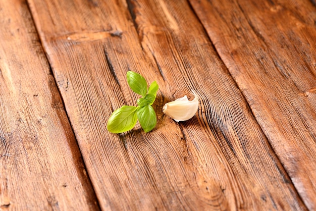 Ajo y albahaca sobre una mesa de madera marrón