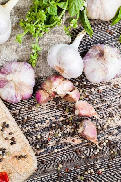 Ajo y especias albahaca fresca en la tabla de cortar durante la cocción, mesa de la cocina durante la cocción de alimentos, primer plano