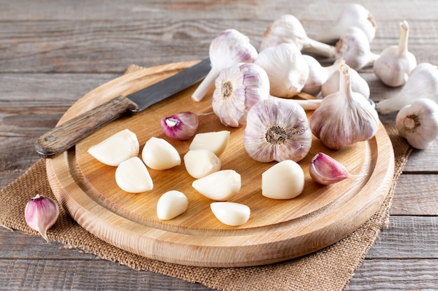 Ajo fresco sobre una tabla para cortar sobre la mesa. Ajo congelado. Concepto de comida congelada