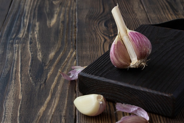 Ajo en una tabla de cortar y una mesa de madera