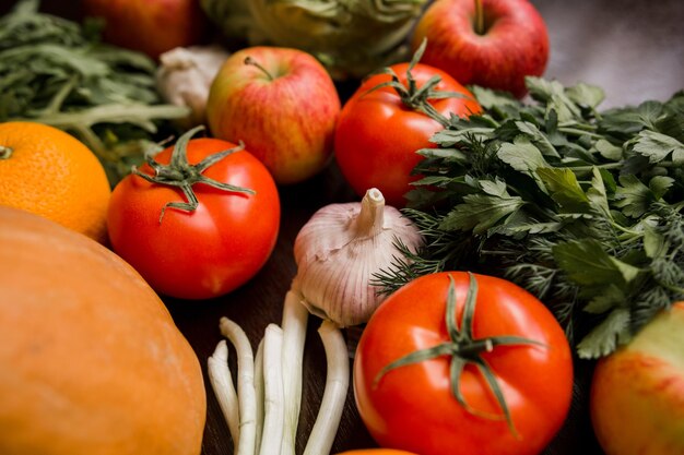 Ajo, tomate, verduras y verduras en la mesa.