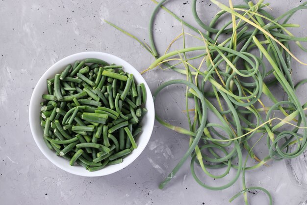 Ajo verde en un tazón blanco sobre fondo gris