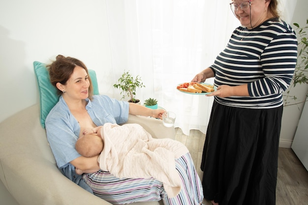 Ajuda de apoio à maternidade para comer à jovem mãe