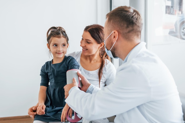 Ajudando a criança Dois médicos de jaleco branco estão na clínica trabalhando juntos