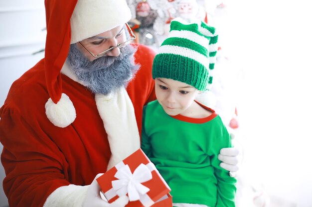 Ajudantes do Papai Noel. Crianças fofas em fantasias de duende do Natal em uma sala lindamente decorada para o Natal. Tempo de milagres. Presentes do Papai Noel.