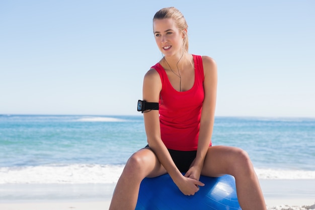 Ajustar a mulher sentada na bola de exercício