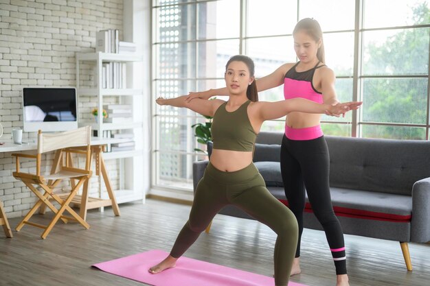 Ajustar jovens amigas fazendo ioga e meditação em casa esporte e estilo de vida saudável conceptx9xA